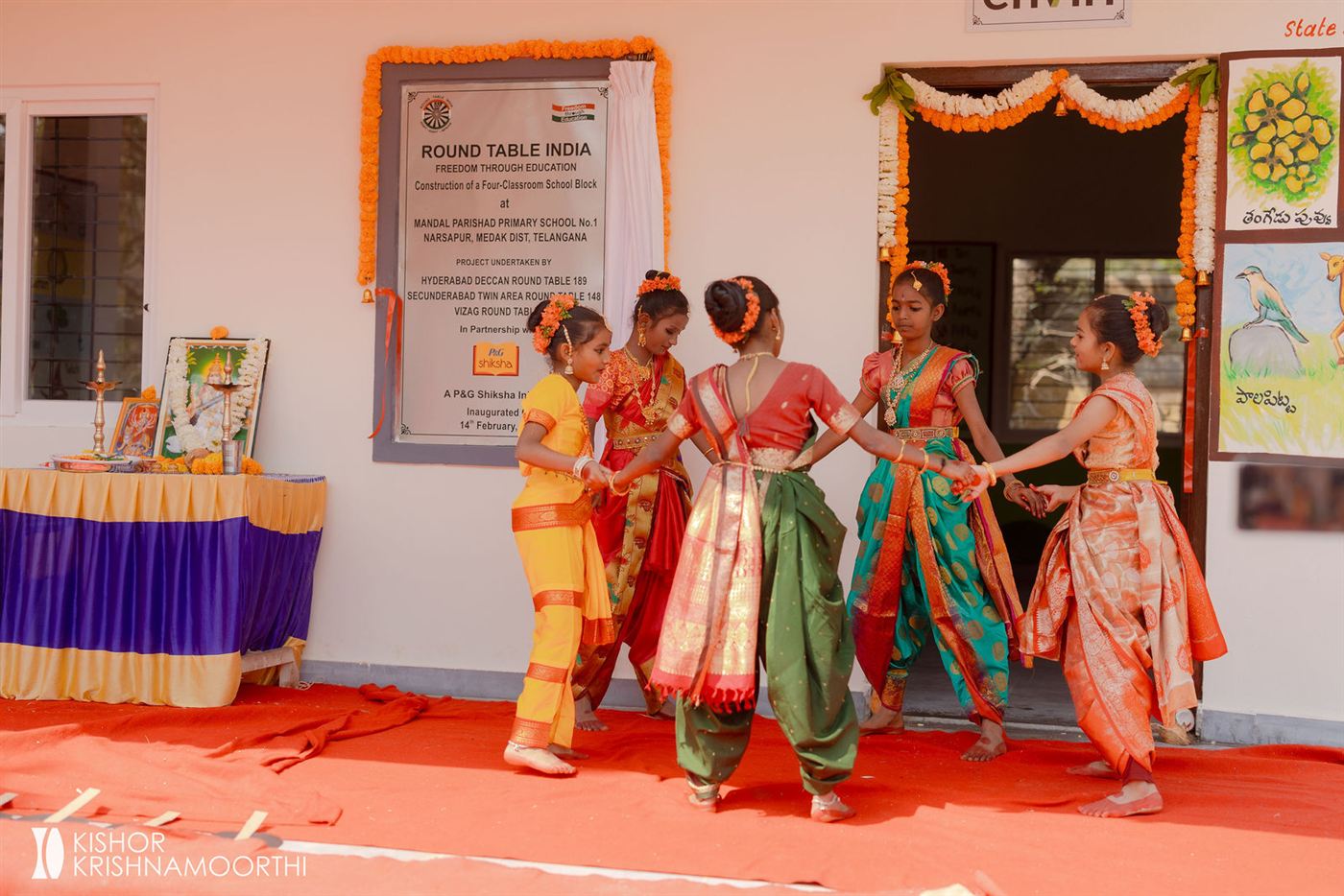 Students performing a dance in front of the new school block